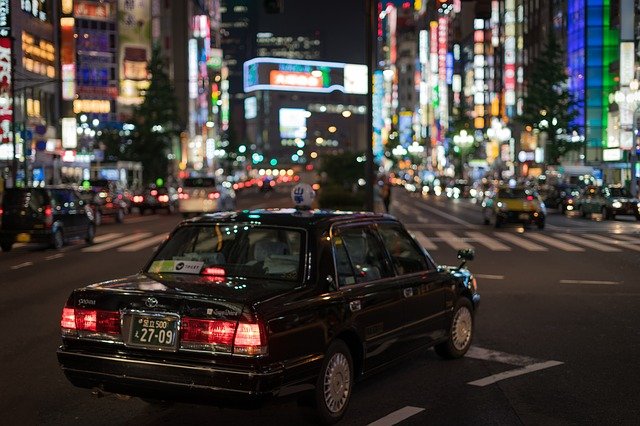 夜の東京にタクシーが走っている画像