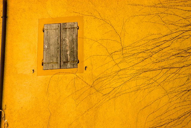 黄色い建物の壁に二階の窓の画像